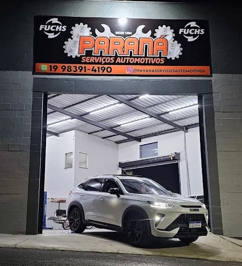 Fachada iluminada da Paraná Serviços Automotivos à noite